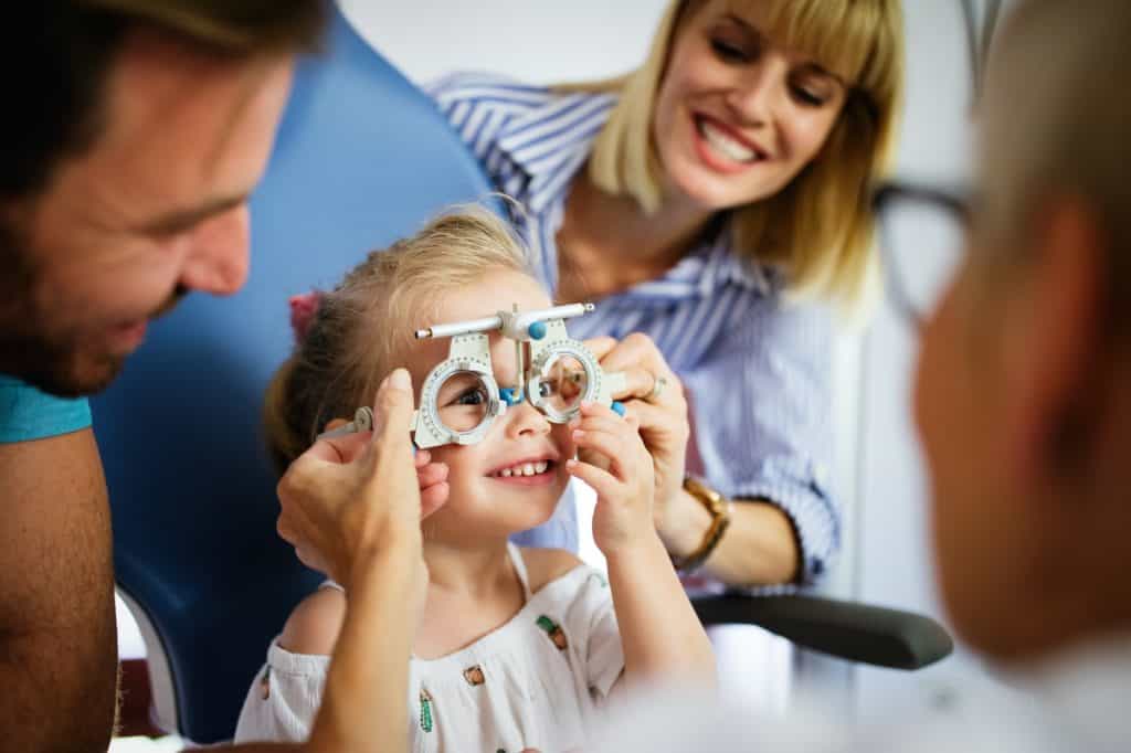 Ophthalmologist, optometrist checking child vision looking for problems and caring for eye