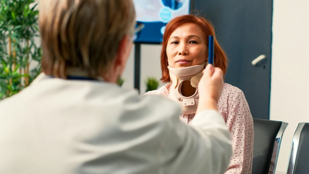 Asian patient with neck collar doing consultation with specialist